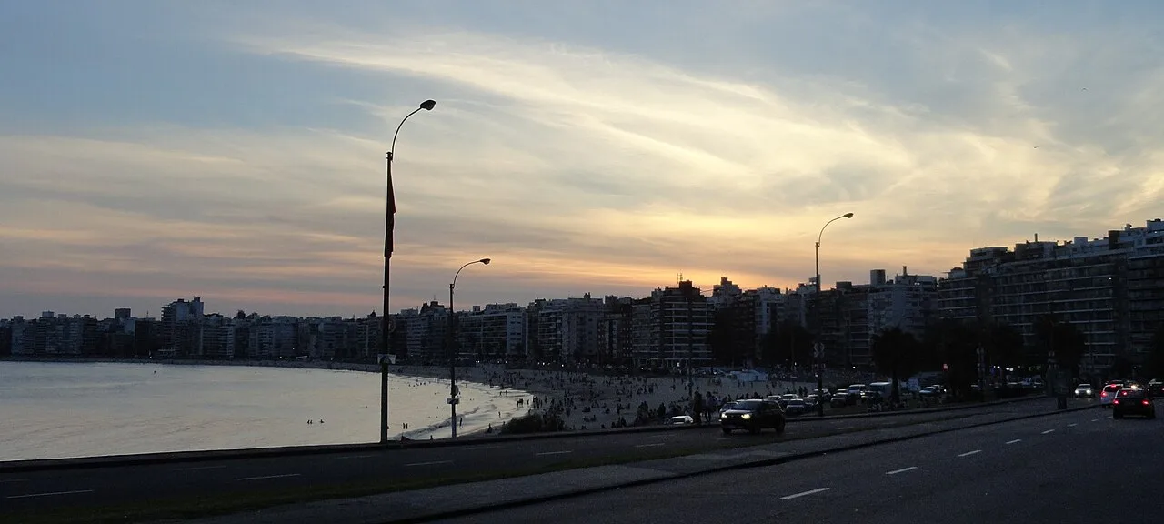 Atardecer sobre la bahía de Pocitos, con la playa, la rambla y el perfil de torres de Pocitos Nuevo al fondo