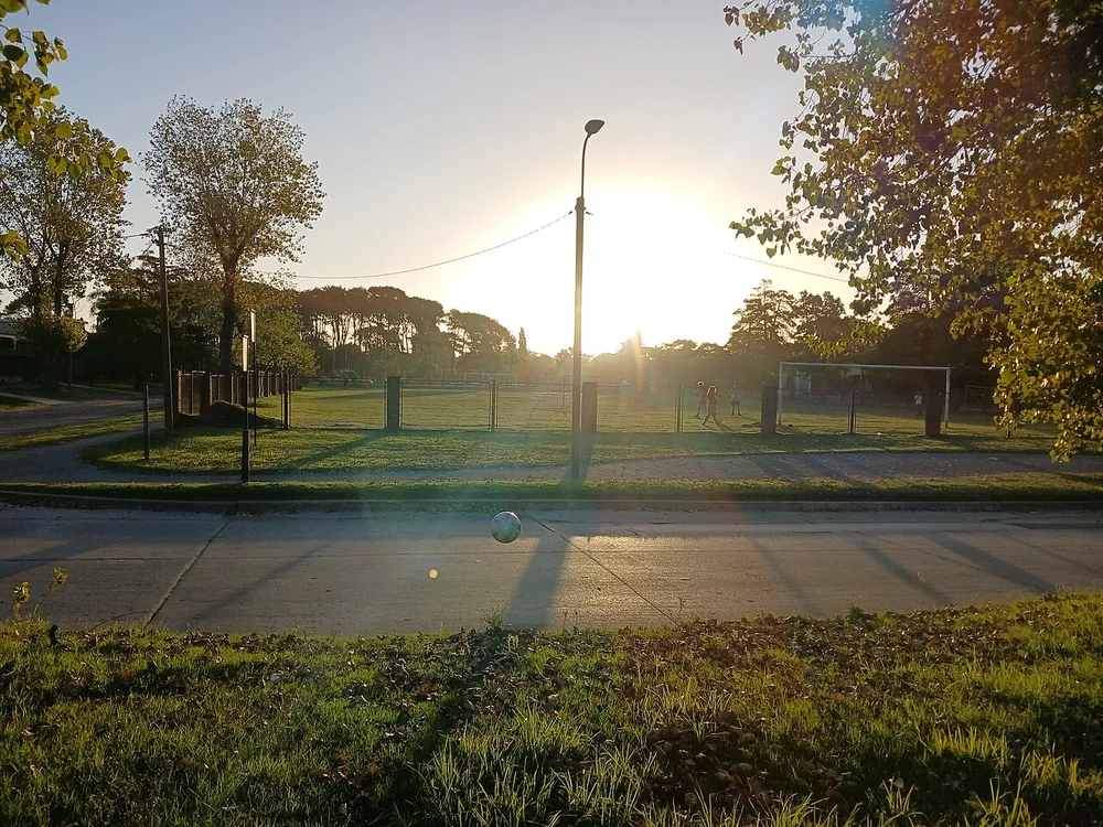 Cancha de fútbol de un club de barrio al atardecer, parte de la vida recreativa de la zona de Carrasco Norte