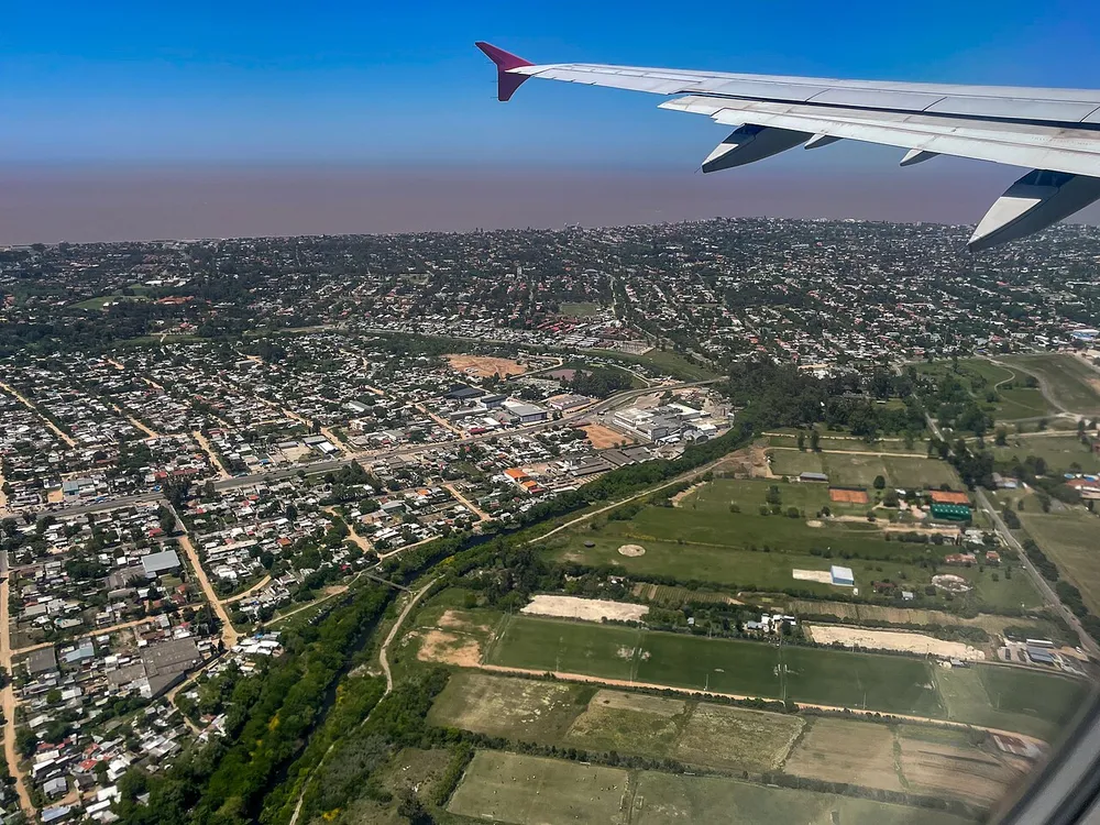 Vista aérea de la zona de Carrasco Norte, con calles arboladas, espacios verdes y canchas deportivas