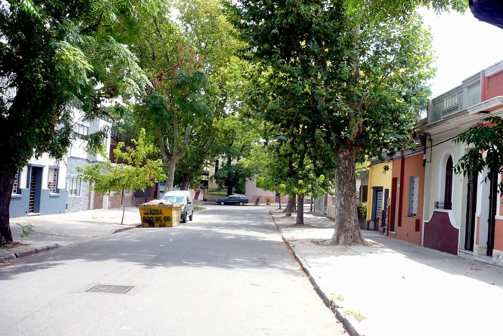 Calle residencial arbolada con casas de distintos colores en el barrio Parque Batlle, Montevideo