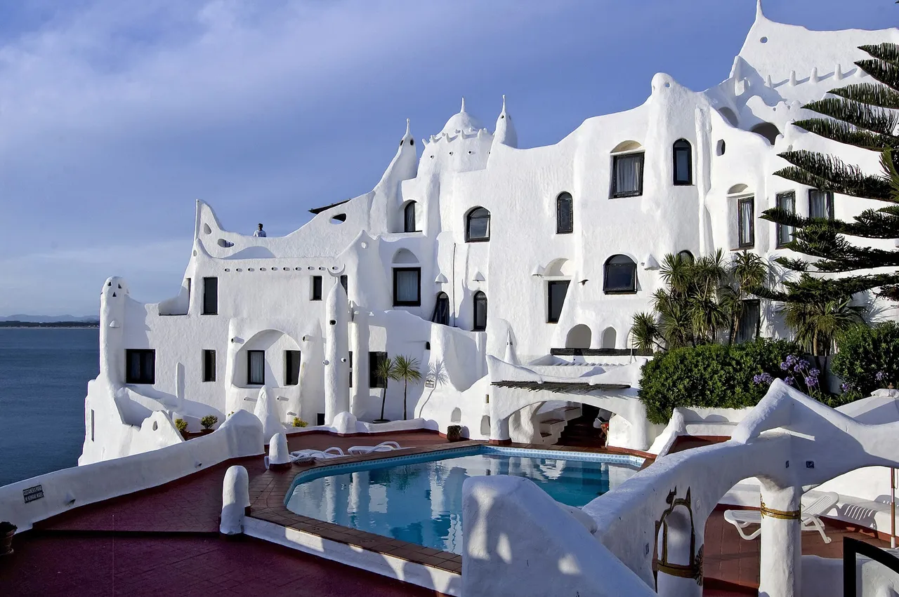 Casapueblo, la escultura habitable de Carlos Páez Vilaró en Punta Ballena, vista desde la piscina junto al mar.