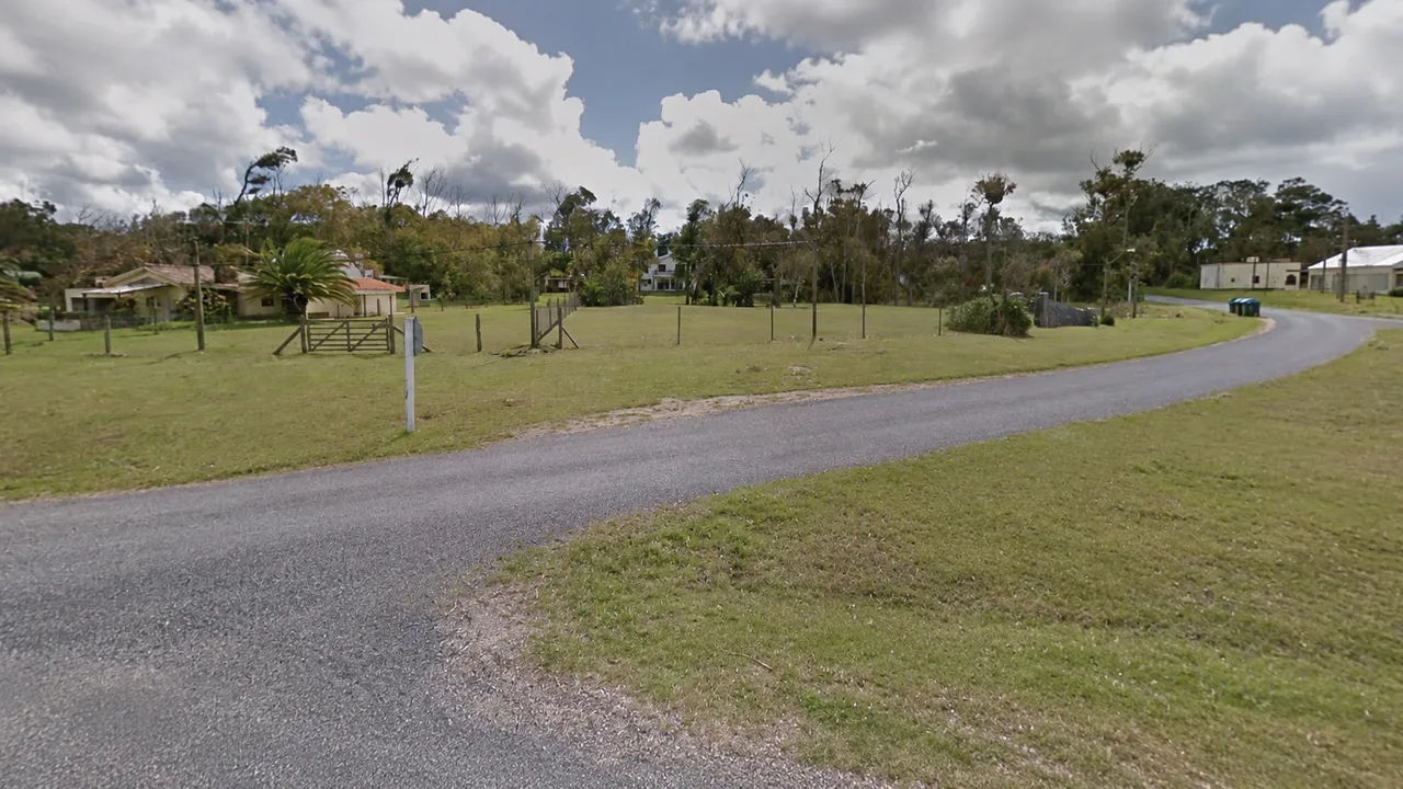 Camino costero en Bella Vista, Maldonado, entre casas y arboleda con pastizales